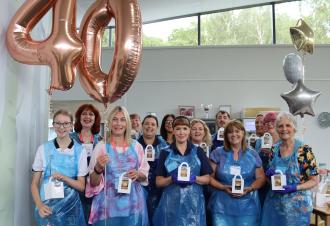 Patients and counselling clients join staff and volunteers to help decorate hospice 40th birthday cakes