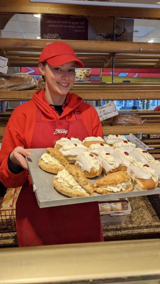 Stacey's Bakery employee Courtney with a tray of bakery goodies